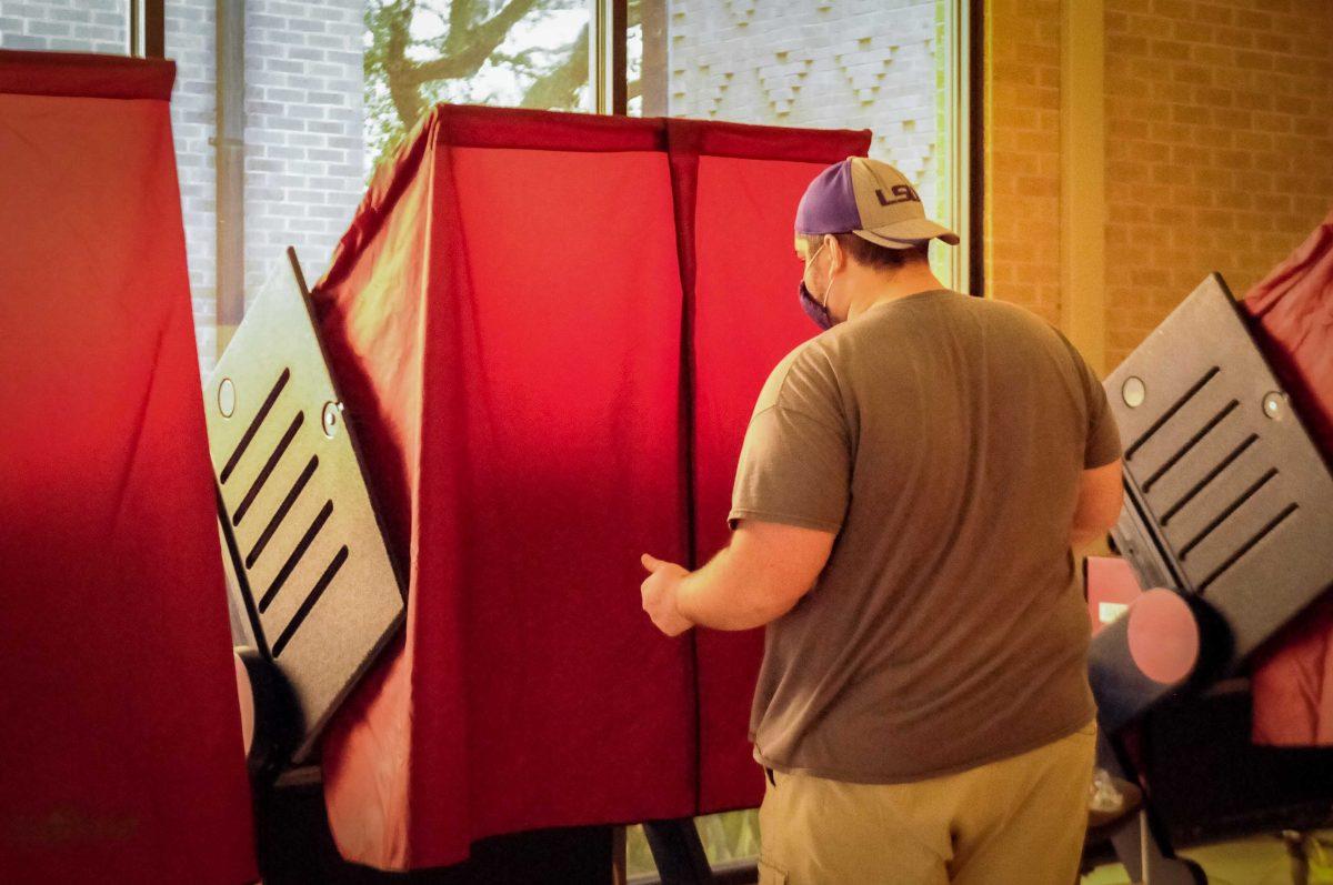 A man enters voting booth on Tuesday, Nov. 3, 2020 at University Laboratory School poll location at 45 Dalrymple Dr.