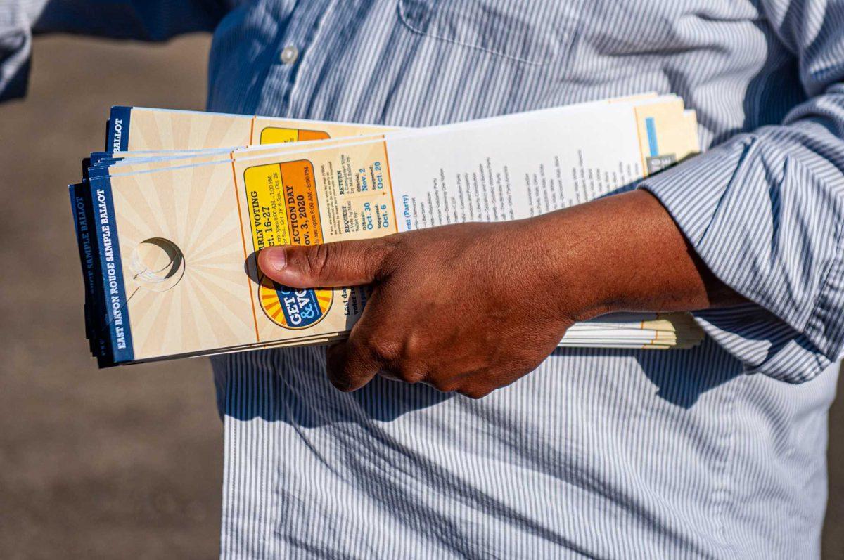 Khalid Hudson holds sample ballots on Tuesday, Nov. 3, 2020 while canvassing neighborhoods on Election Day in Baton Rouge, LA.