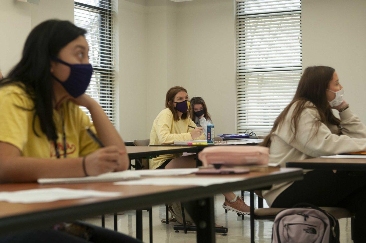 Students take notes Wednesday, Jan. 20, 2021 while social distancing in MC 2010 class in West Hall.