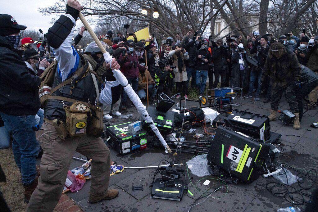 Demonstrators break TV equipment outside the the U.S. Capitol on Wednesday, Jan. 6, 2021, in Washington.&#160;