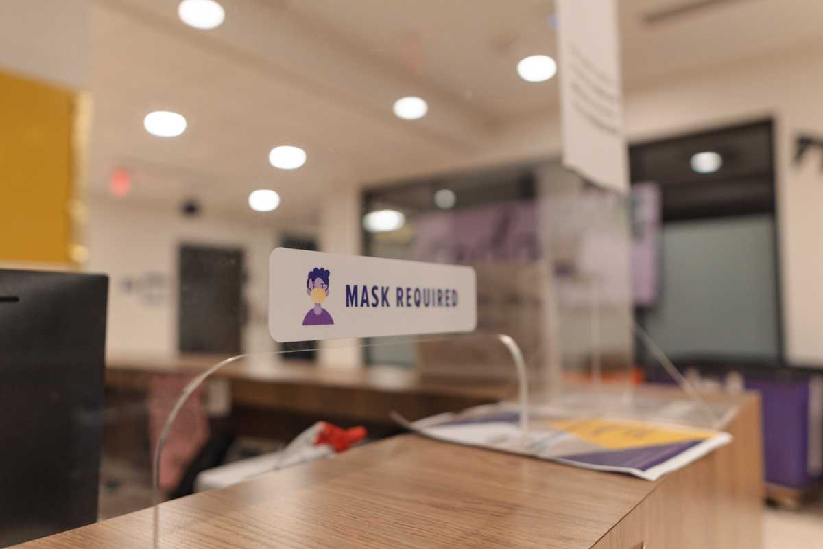 A sticker reads &#8220;Mask Required&#8221; on Jan. 16, 2021 on the divider at the Cedar Hall front desk.