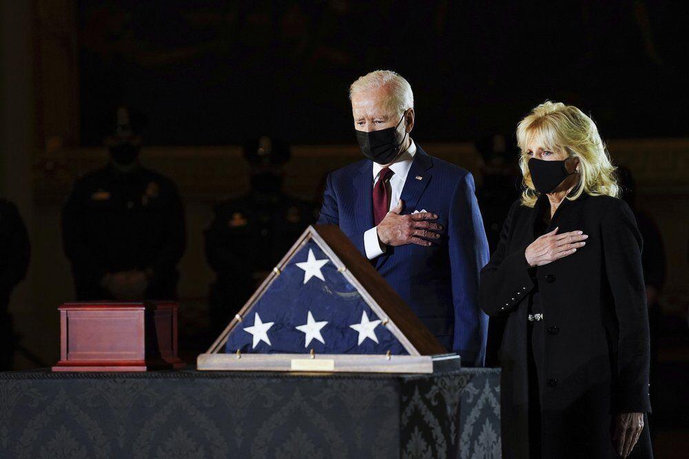 FILE - President Joe Biden and first lady Jill Biden pay their respects to the late U.S. Capitol Police officer Brian Sicknick as an urn with his cremated remains lies in honor on a black-draped table at center of Capitol Rotunda, Tuesday, Feb. 2, 2021, in Washington. (Erin Schaff/The New York Times via AP, Pool)