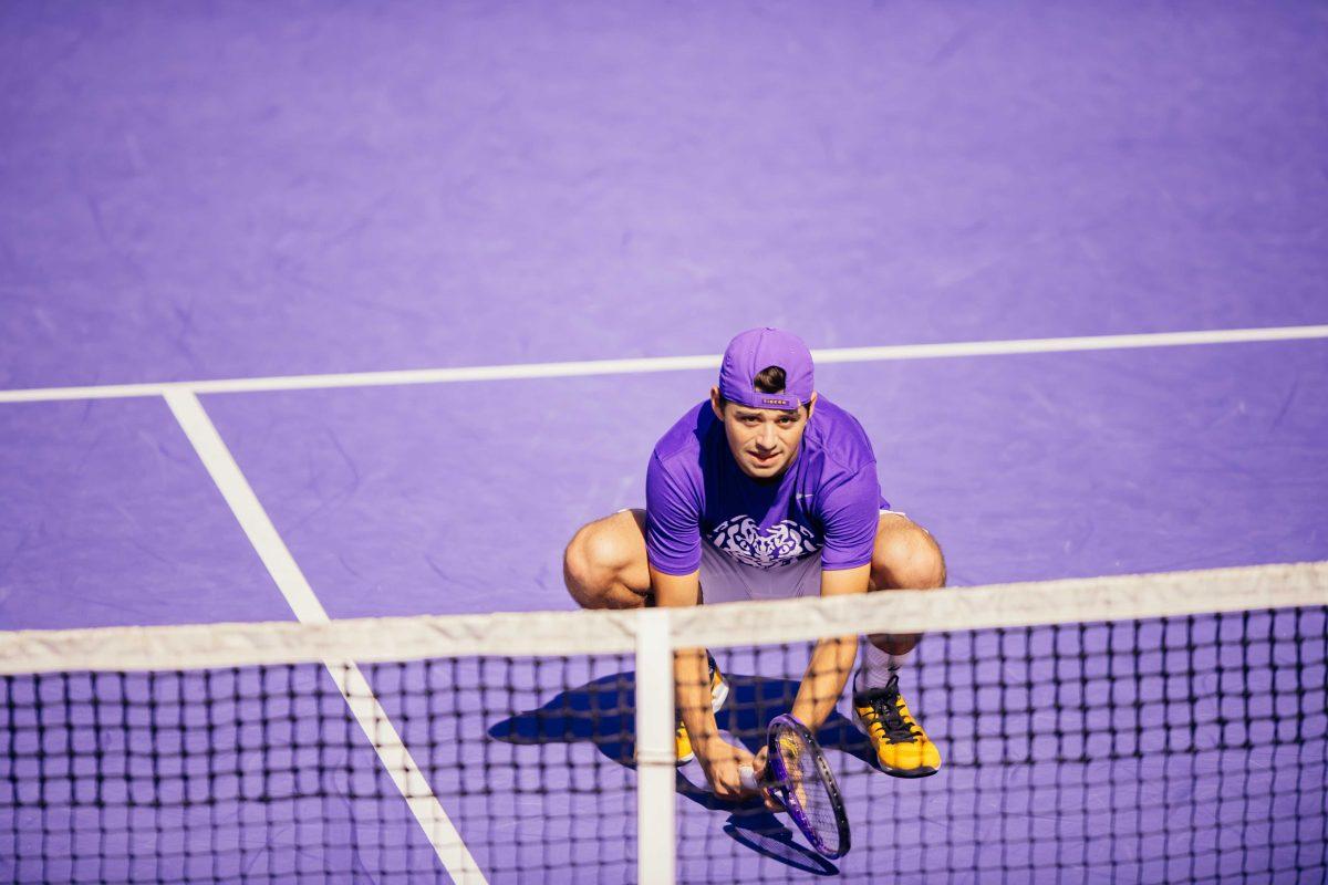 LSU men's tennis redshirt-freshman Ronald Hohmann bends down for the serve Sunday, Jan. 31, 2021 during LSU's 4-1 win over Rice at the LSU Tennis Complex on Gourrier Avenue in Baton Rouge, La.