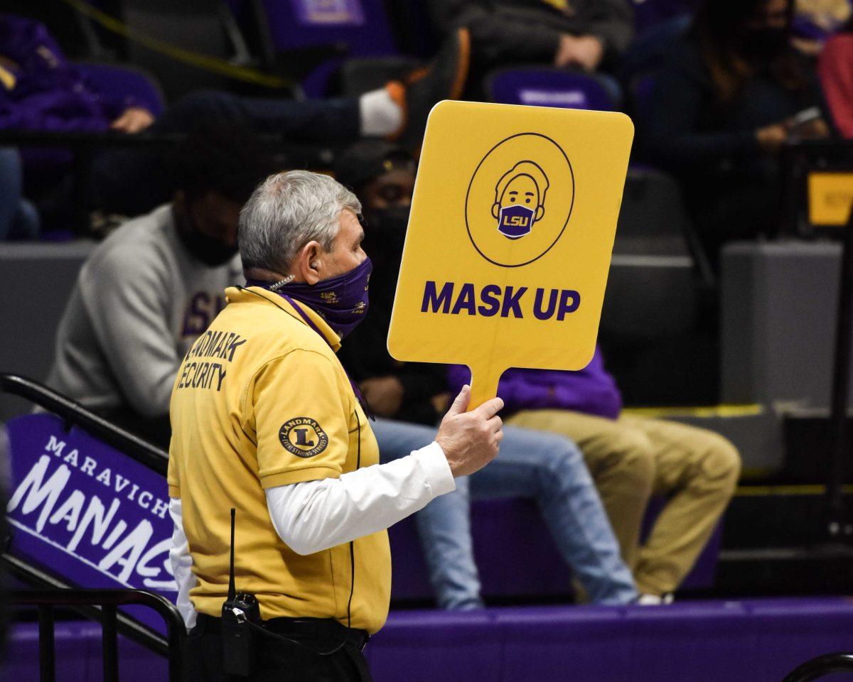 Landmark Security guard holds a "Mask Up" sign Saturday, Feb. 20, 2021 during LSU's 104-80 win against Auburn at the Pete Maravich Assembly Center on N Stadium Drive in Baton Rouge, La.