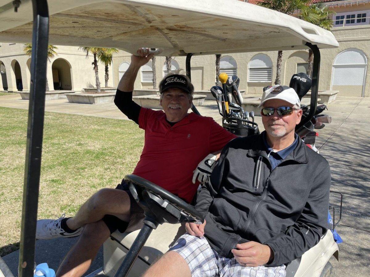 Mark Ellis and Allen Stall, two regulars at BREC golf courses, ride in a golf cart before they play a fresh set of 18 holes.