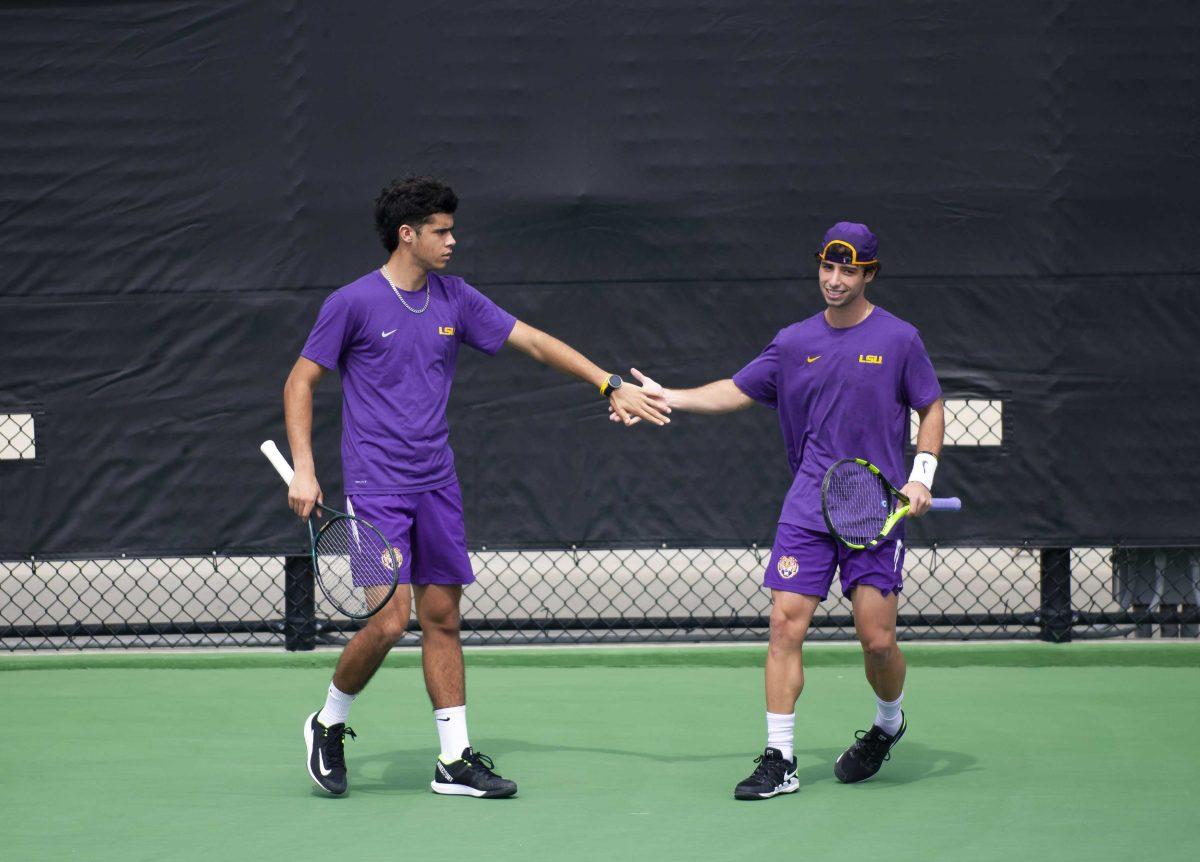 LSU men&#8217;s tennis freshman Joao Graca and LSU men&#8217;s tennis redshirt junior Joey Thomas high five after scoring a point Sunday, Feb. 28, 2021 during LSU&#8217;s 1-4 loss against South Carolina in the LSU Tennis Complex on Gourrier Avenue in Baton Rouge.