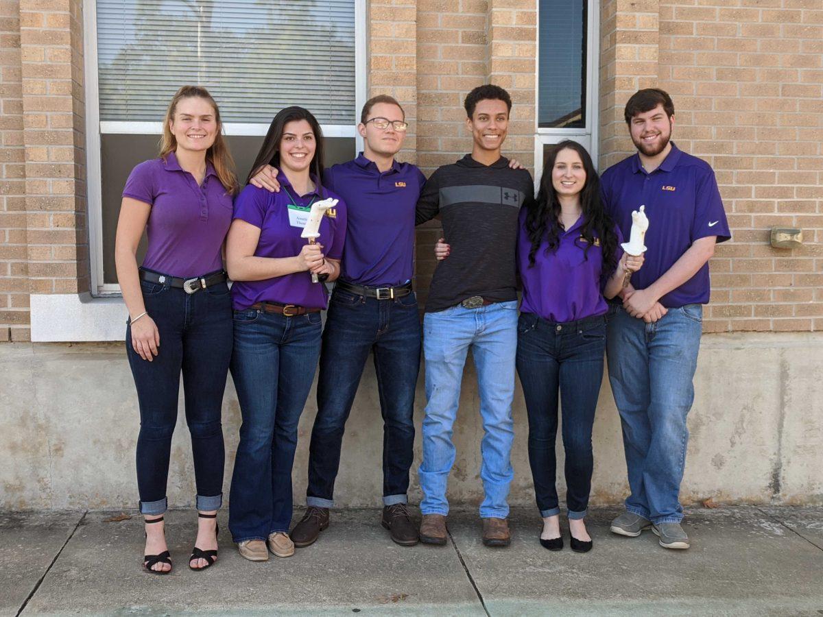 LSU alumni Amelie Thomas, Gary Couturie, Landon Stein, Cecilia McAlear and Brette Crocker with Catholic High student James Robert III.