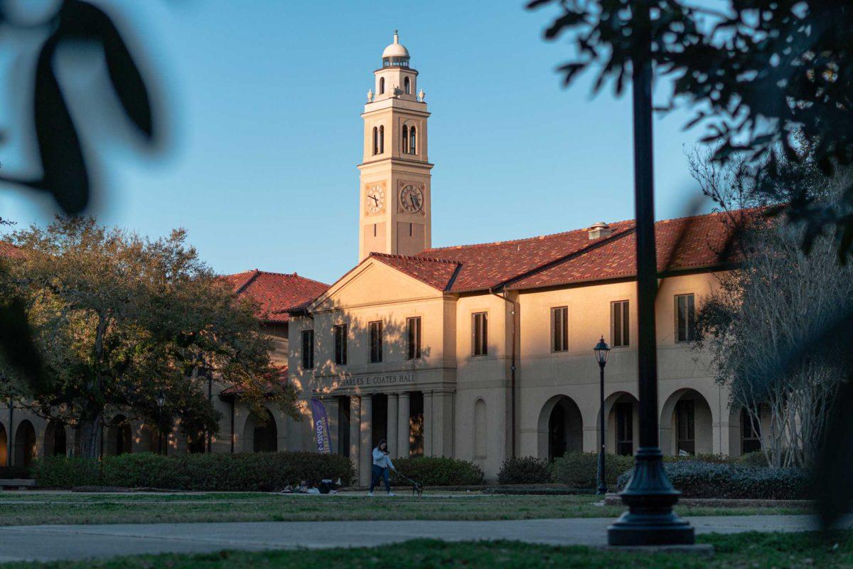 A woman walks her dog on Mar. 3, 2021 through the Quad.