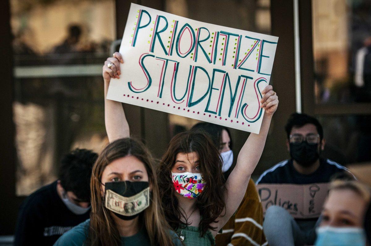 Mass communication senior Mia LeJune displays a sign while blockading entrance on Monday, March 8, 2021 during the Tigers Against Sexual Assault sit-in at the Football Operations Center on Skip Bertman Drive.