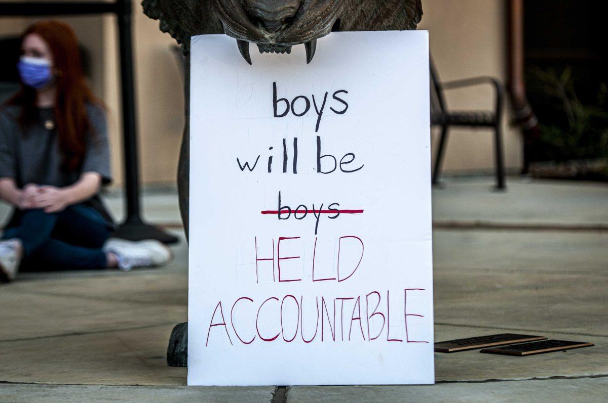 A sign is placed in the mouth of a tiger statue on Monday, March 3, 2021 during the Tigers Against Sexual Assault sit-in at the Football Operations Center on Skip Bertman Drive.