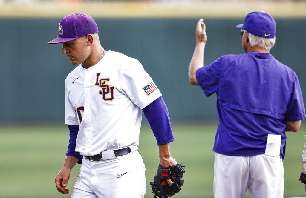 LSU pitcher Trent Vietmeier, left, leaves the field as coach Paul Mainieri makes the call to the bullpen during an NCAA college baseball super regional game against Tennessee, Sunday, June 13, 2021, in Knoxville, Tenn. (AP Photo/Wade Payne)