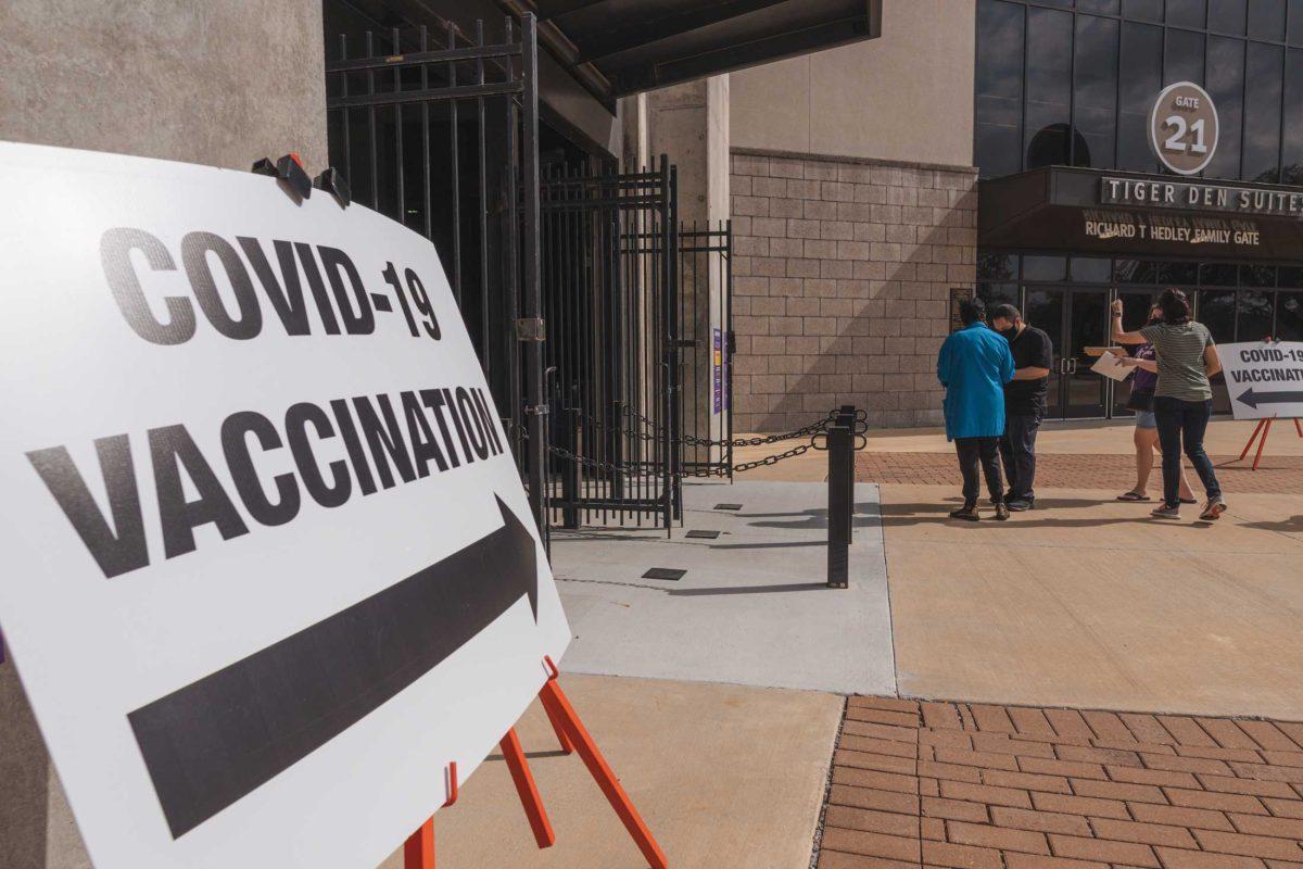 People stand in line while filling out paperwork on Mar. 14, 2021 at the Tiger Stadium vaccination site.