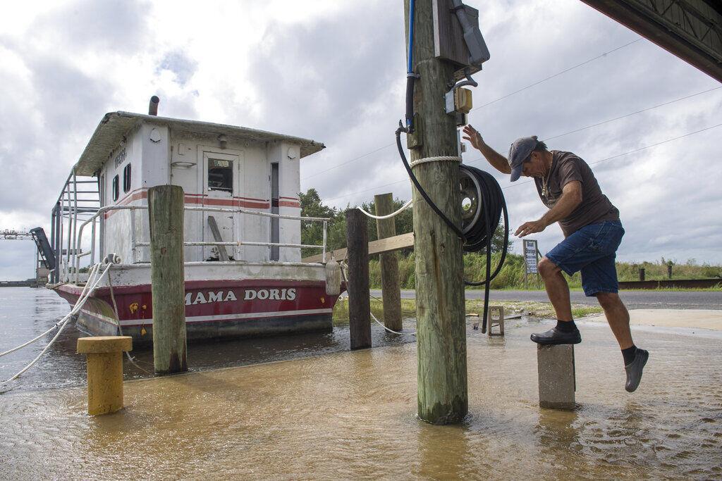 Don Robin stands on a concrete block as the water rises in eastern St. Bernard Parish, La., as Hurricane Sally heads toward the Gulf Coast on Monday, Sept. 14, 2020. Robin was making sure one of his oyster boats was safely secured.&#160;