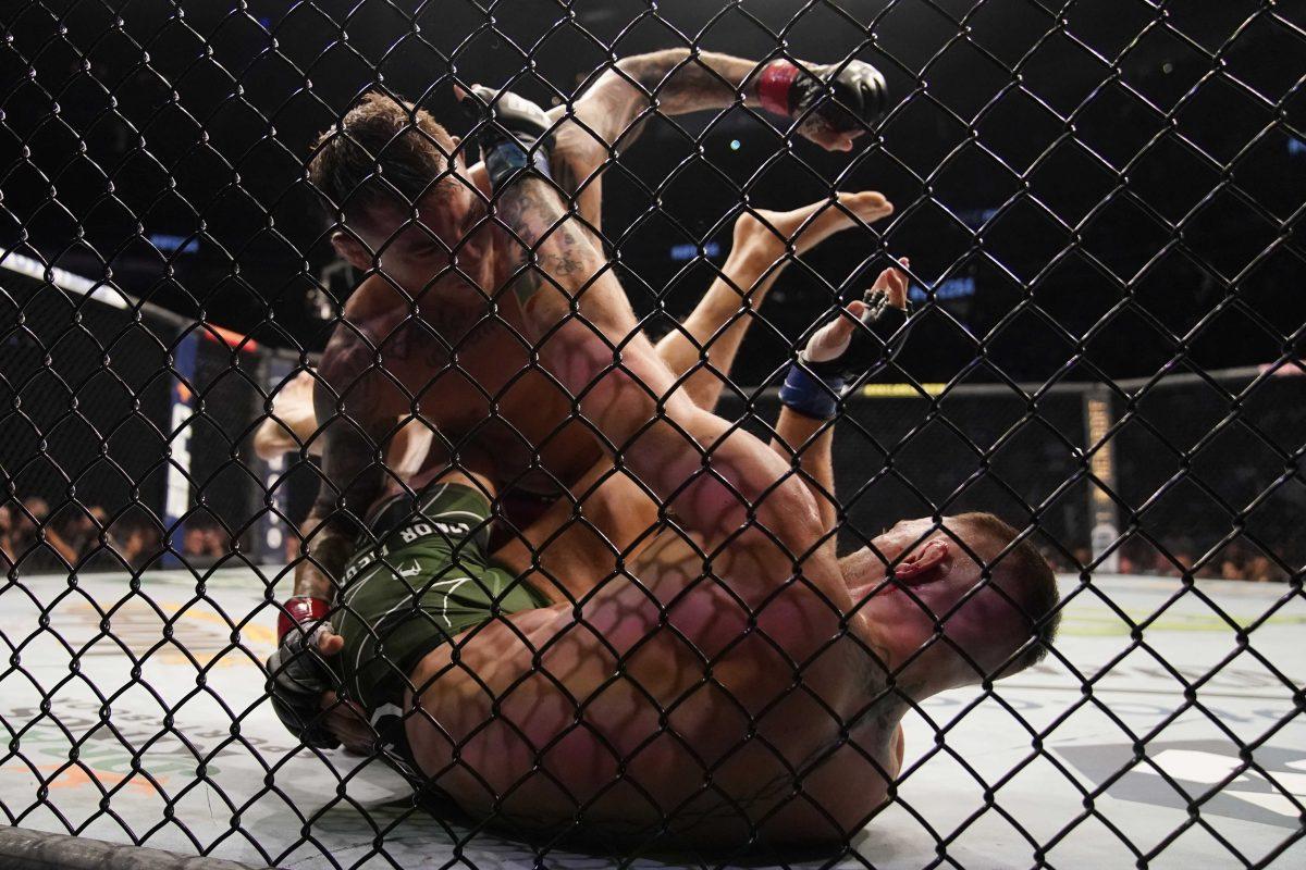 Dustin Poirier, top, punches Conor McGregor during a UFC 264 lightweight mixed martial arts bout Saturday, July 10, 2021, in Las Vegas. (AP Photo/John Locher)