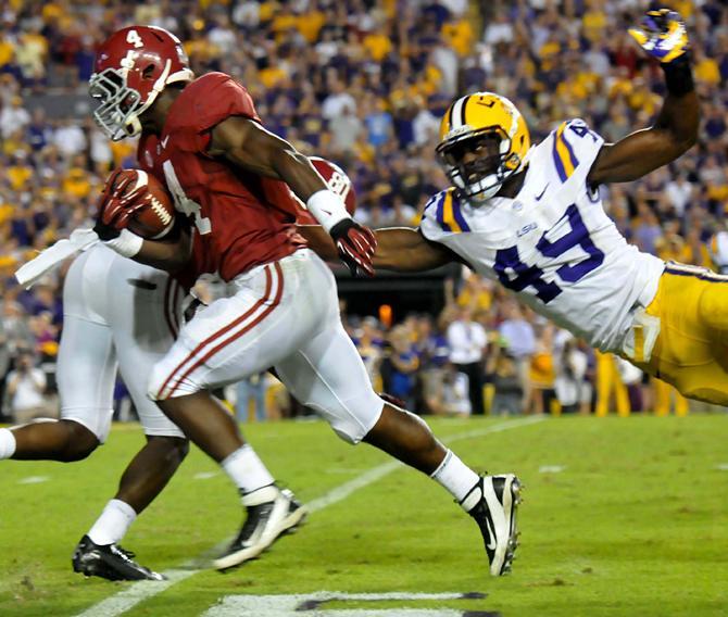 LSU junior defensive end Barkevious Mingo (49) attempts to stop Alabama running back T.J. Yeldon on his game-winning drive Saturday, Nov. 3, 2012 during the Tigers' 21-17 loss against Alabama in Tiger Stadium.