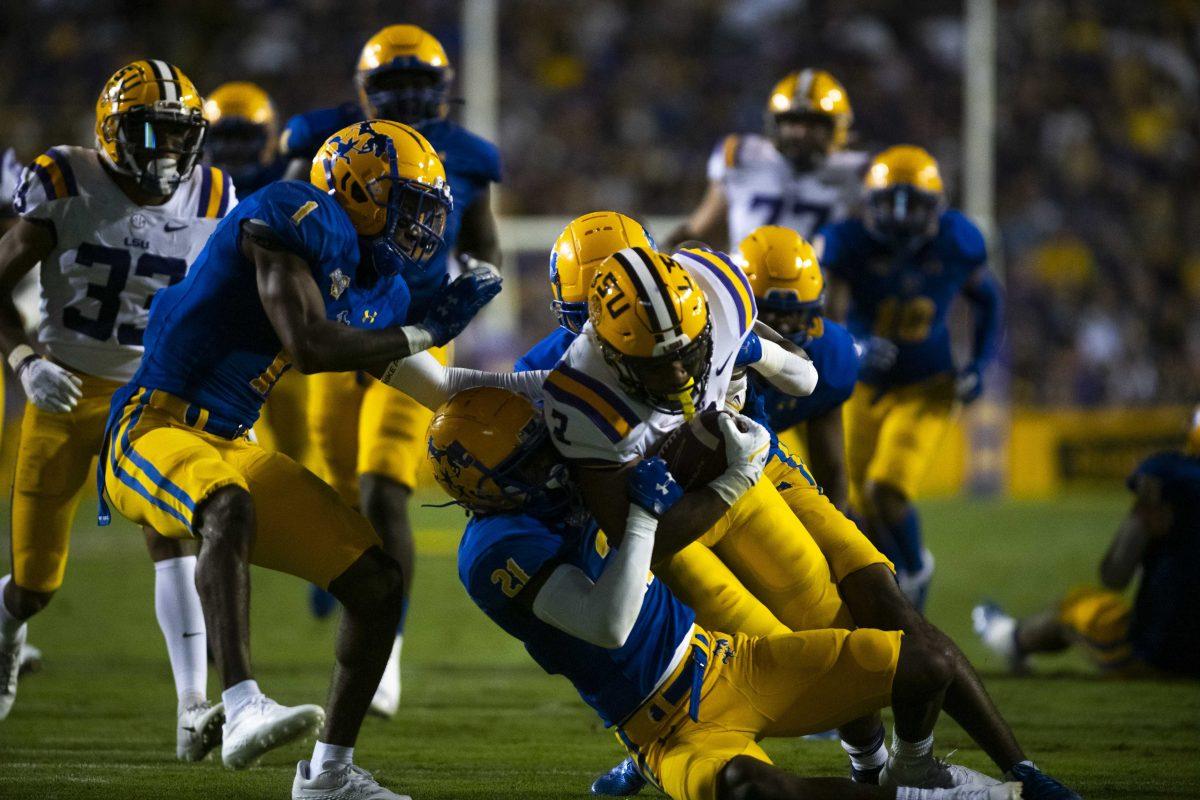 LSU football junior running back Tyrion Davis-Price (3) fights through a tackle by McNeese State junior defensive back Andre Sam (21) Saturday, Sept. 11, 2021, during LSU&#8217;s 34-7 win against McNeese State University at Tiger Stadium in Baton Rouge, La.