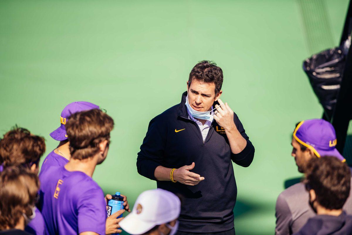 LSU men's tennis co-head coach Chris Brandi pulls down his mask to talk to the team Sunday, Jan. 31, 2021 during LSU's 4-1 win over Rice at the LSU Tennis Complex on Gourrier Avenue in Baton Rouge, La.