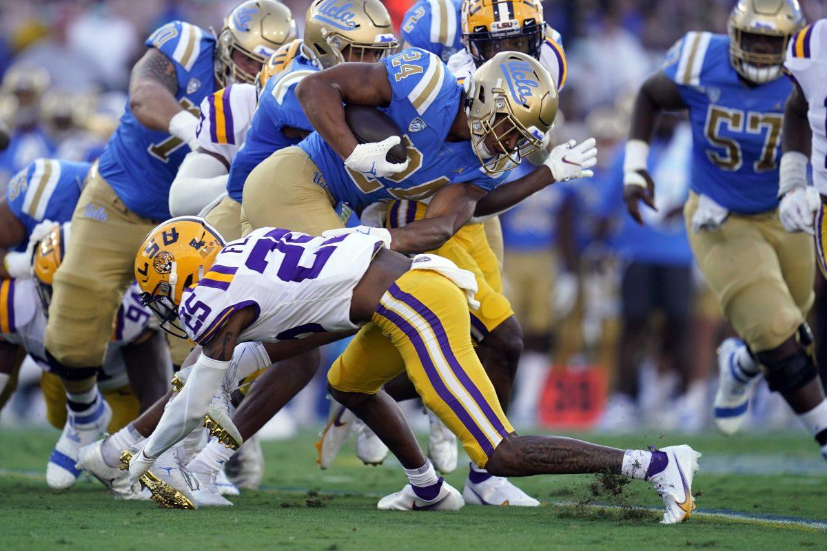 UCLA running back Zach Charbonnet (24) is tackled by LSU cornerback Cordale Flott (25) during the first half of an NCAA college football game Saturday, Sept. 4, 2021, in Pasadena, Calif. (AP Photo/Marcio Jose Sanchez)