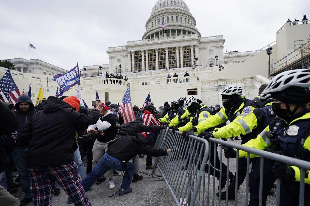 In this Jan. 6, 2021 file photo, rioters try to break through a police barrier at the Capitol in Washington. People charged in the attack on the U.S. Capitol left behind a trove of videos and messages that have helped federal authorities build cases. In nearly half of the more than 200 federal cases stemming from the attack, authorities have cited evidence that an insurrectionist appeared to have been inspired by conspiracy theories or extremist ideologies, according to an Associated Press review of court records.&#160;