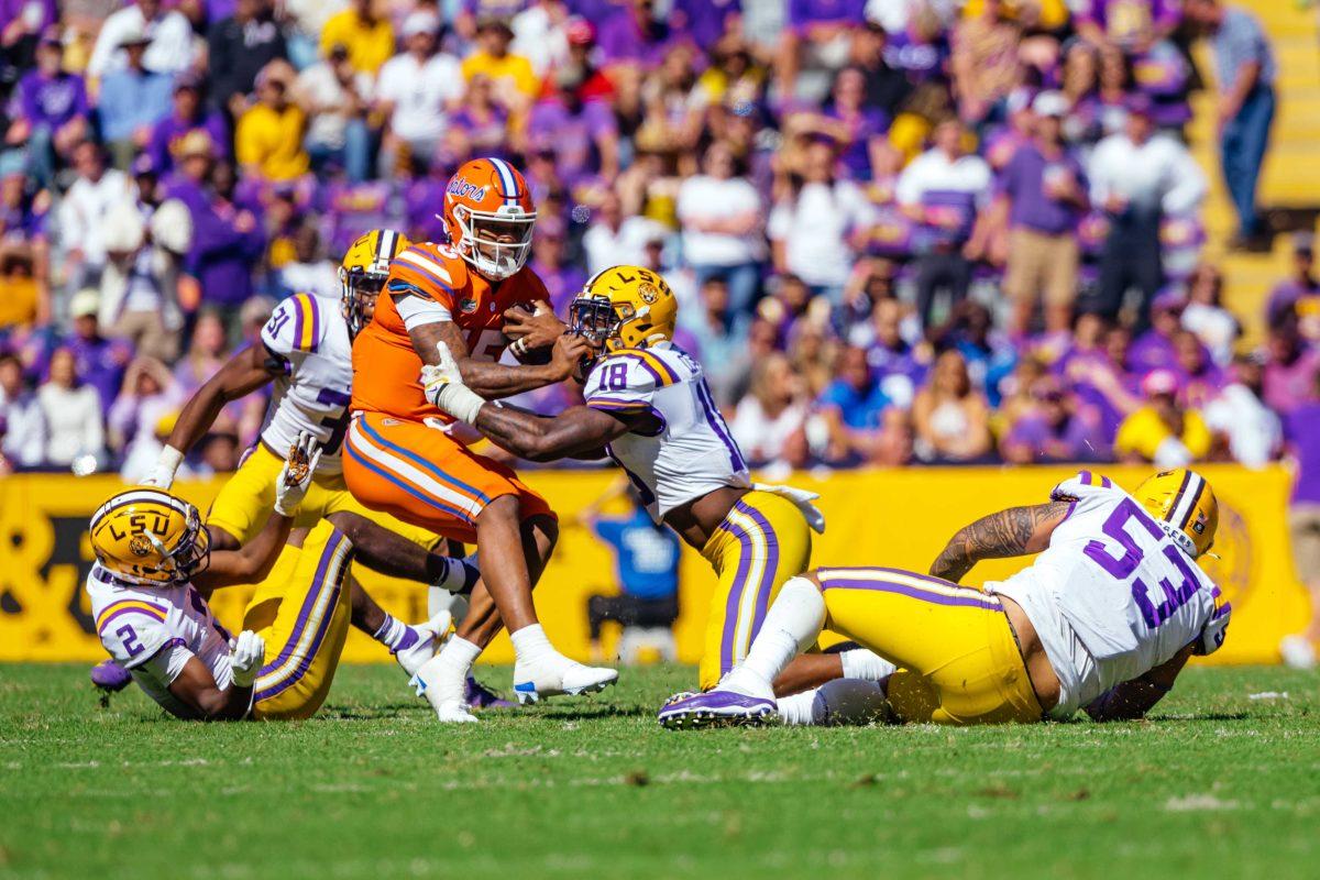 LSU football senior linebacker Damone Clark (18) and senior defensive end Soni Fonua (53) tackle Florida redshirt-freshman quarterback Anthony Richardson (15) Saturday, Oct. 16, 2021, during LSU's 49-42 win against Florida at Tiger Stadium in Baton Rouge, La.