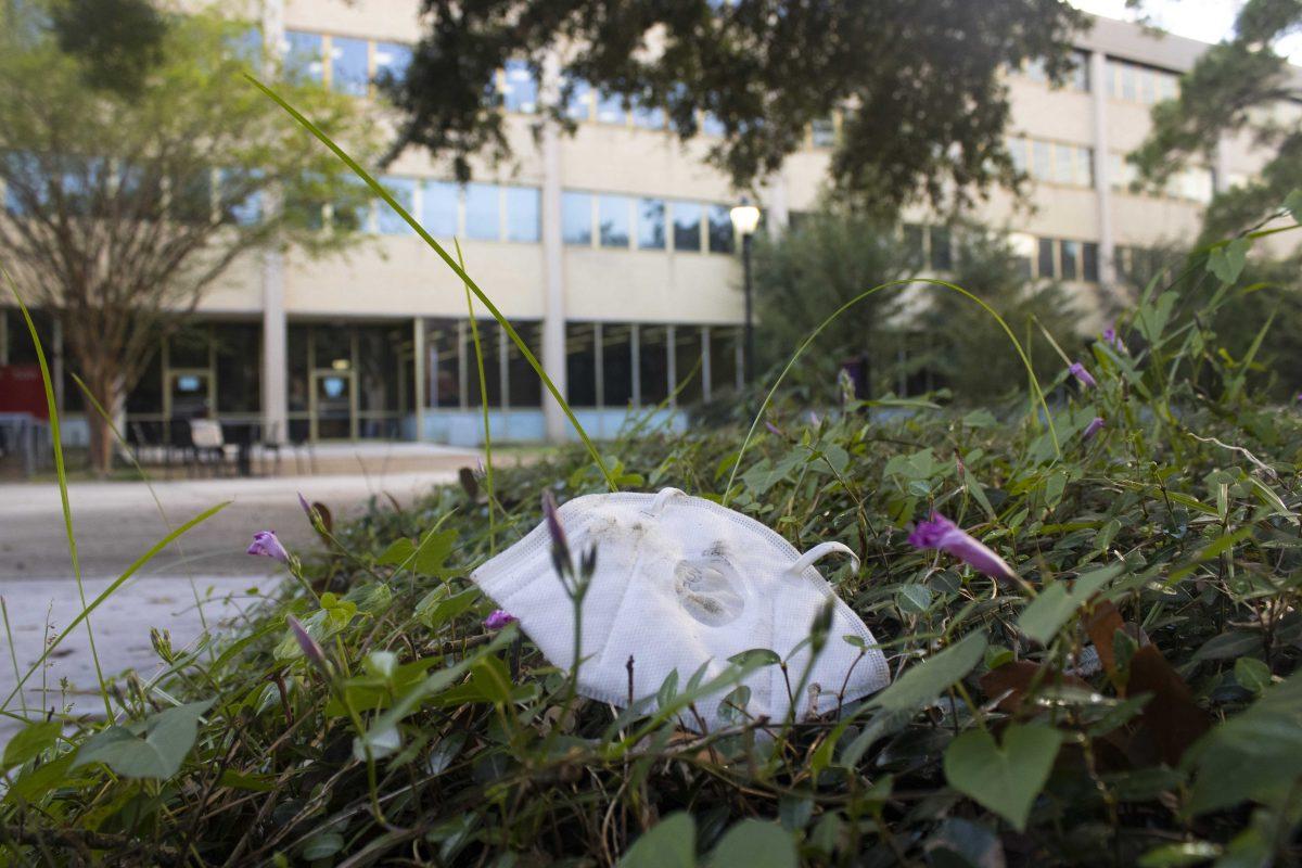 A white mask lays in the grass Sunday, Oct. 24, 2021 behind LSU Library on LSU's campus.