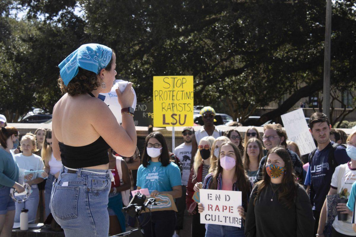 A group of protestors gather around second year political science and history major Annie Sheehan-Dean Monday, Oct. 18, 2021, as she speaks during the Feminists in Action protest following reports of LSU mishandling sexual assault cases on the Parade Ground at LSU's campus.