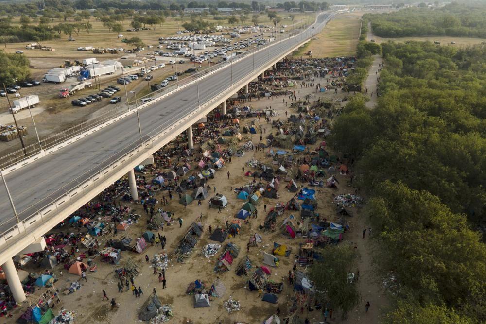 Migrants, many from Haiti, are seen at an encampment along the Del Rio International Bridge near the Rio Grande, Tuesday, Sept. 21, 2021, in Del Rio, Texas. The options remaining for thousands of Haitian migrants straddling the Mexico-Texas border are narrowing as the United States government ramps up to an expected six expulsion flights to Haiti and Mexico began busing some away from the border.