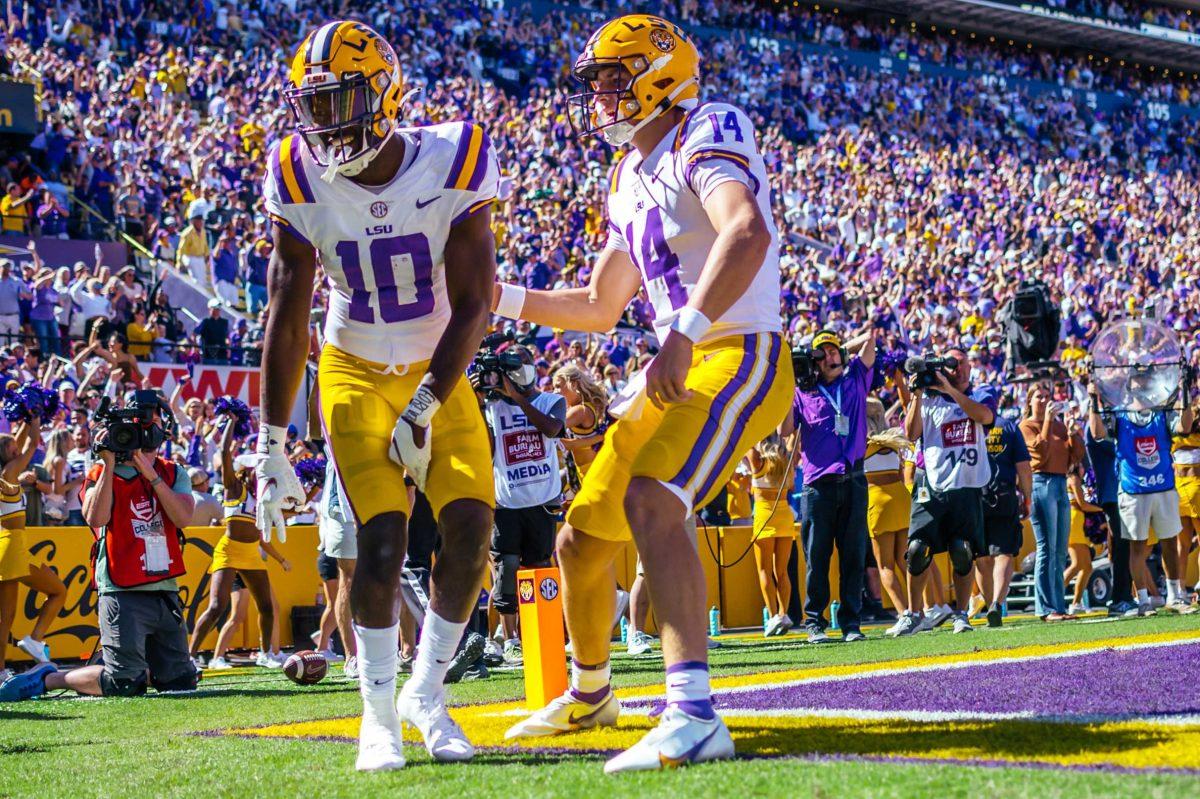 LSU football junior wide receiver Jaray Jenkins (10) makes a touchdown and dances with sophomore quarterback Max Johnson (14) Saturday, Oct. 16, 2021, during LSU's 49-42 win against Florida at Tiger Stadium in Baton Rouge, La.