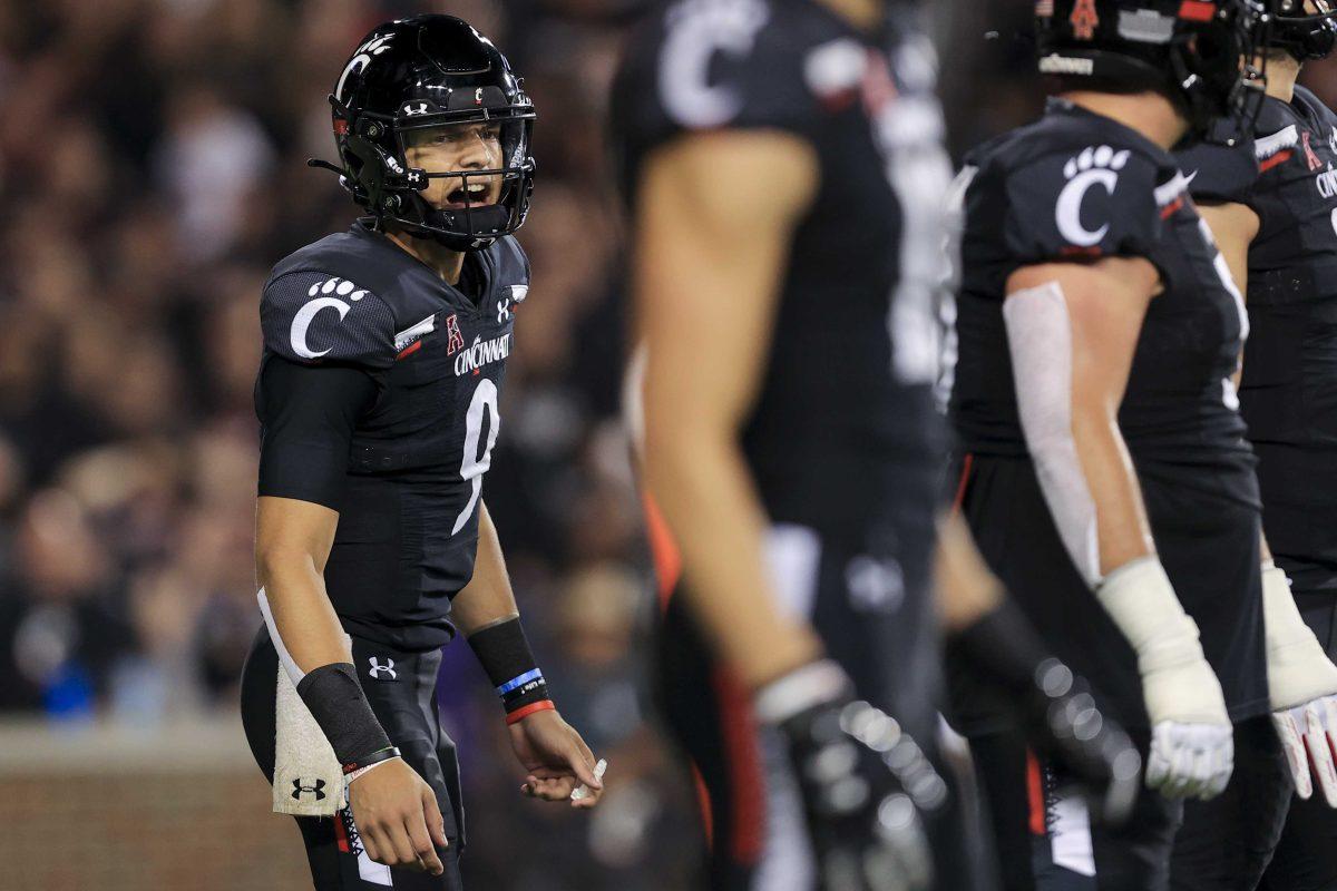 Cincinnati quarterback Desmond Ridder yells to teammates prior to a play at the line of scrimmage during the second half of an NCAA college football game against Temple, Friday, Oct. 8, 2021, in Cincinnati. Cincinnati won 52-3. (AP Photo/Aaron Doster)