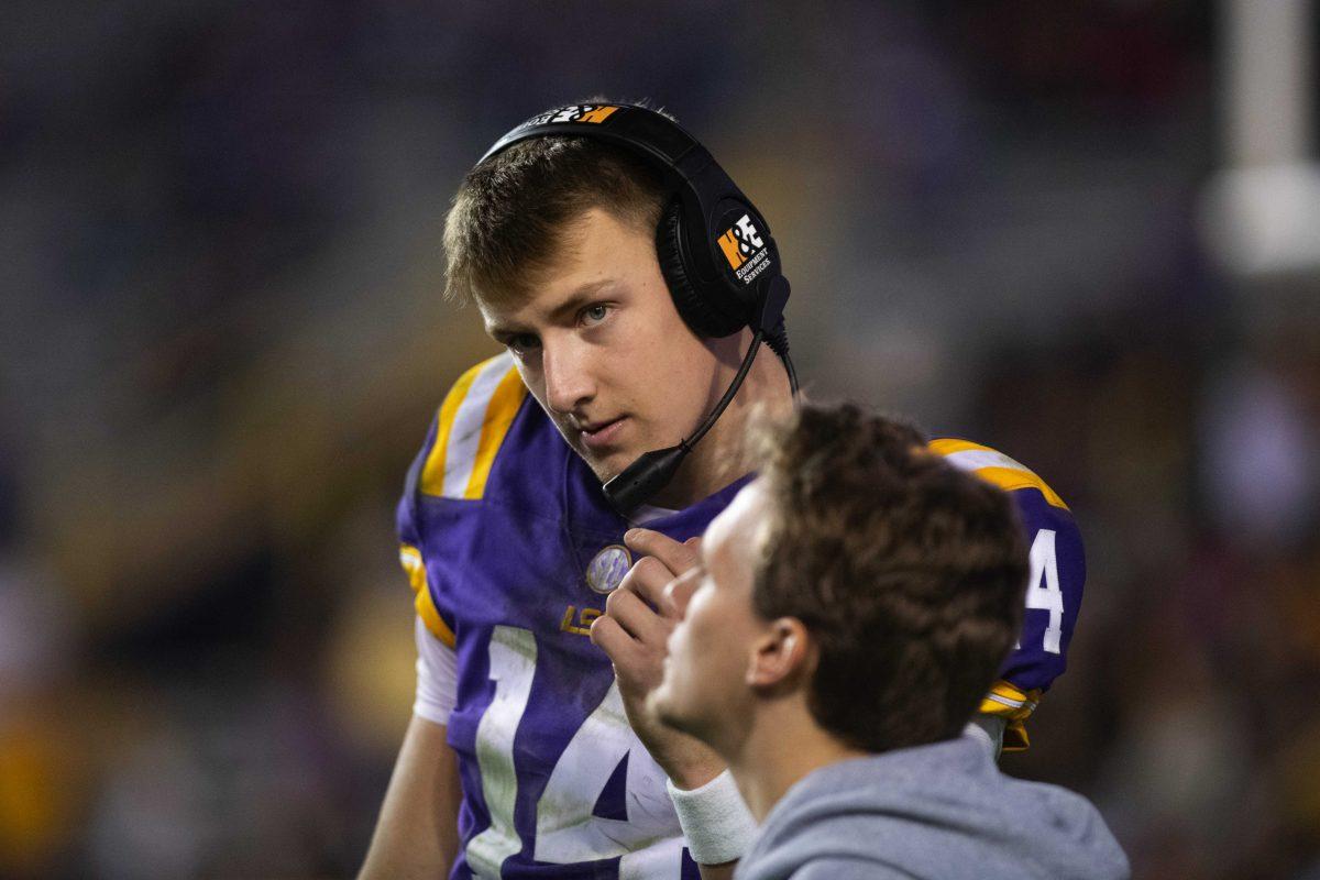 LSU football sophomore quarterback Max Johnson (14) listens to someone speaking through a headset Saturday, Nov. 20, 2021, during LSU&#8217;s 27-14 win against ULM in Tiger Stadium on North Stadium Drive in Baton Rouge, La.