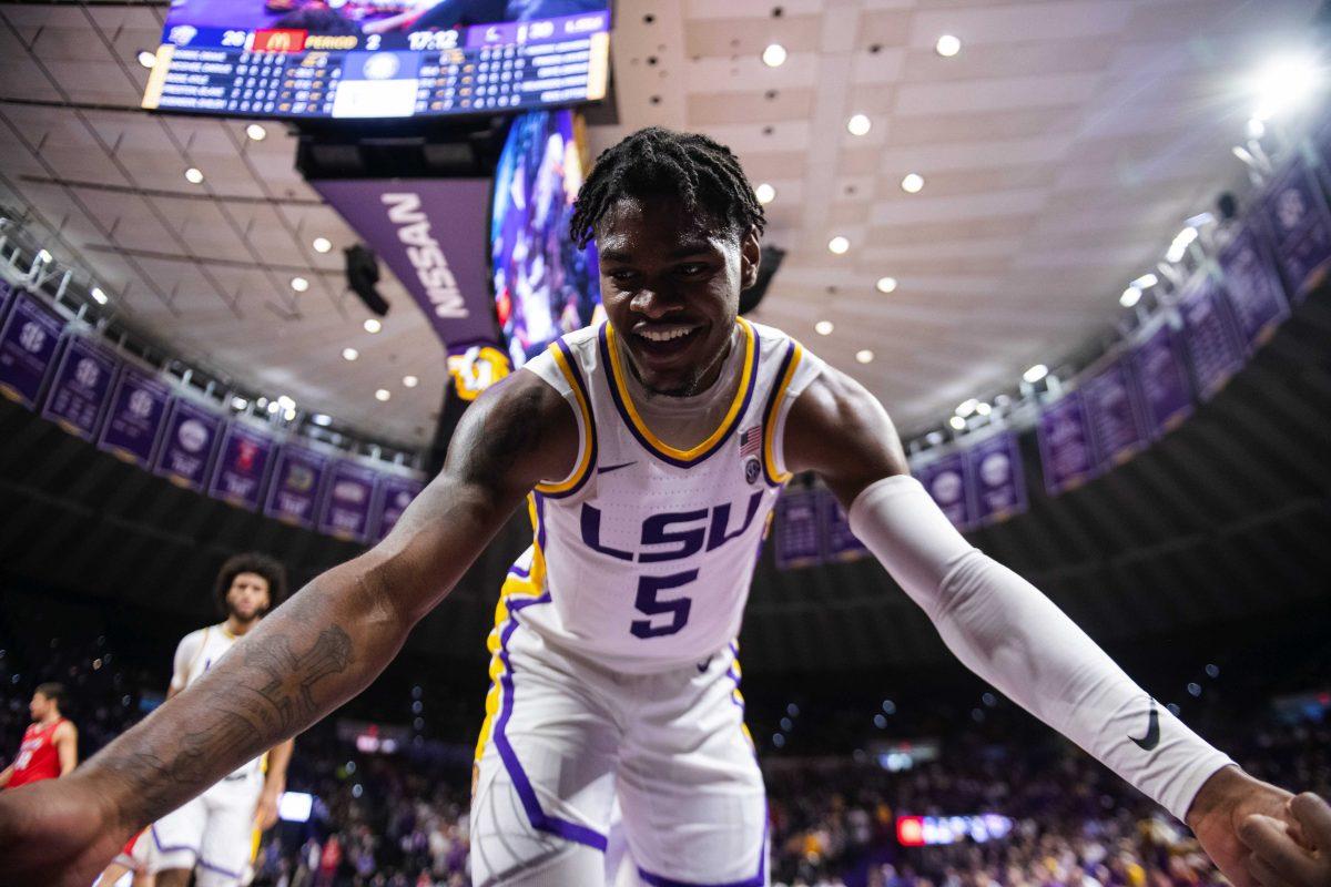 LSU men&#8217;s basketball sophomore forward Mwani Wilkinson (5) helps up senior forward Darius Days (4) and freshman guard Brandon Murray (0) after they fall to the ground Monday, Nov. 15, 2021, during LSU&#8217;s 74-58 win against Liberty in the Pete Maravich Assembly Center on North Stadium Drive in Baton Rouge, La.