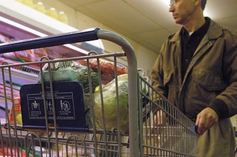 Lettuce, brocolli and other healthy food sit in the child seat of a grocery cart while Leon LeJeune of Baton Rouge shops for Thanksgiving at Bet-R Supermarket on the corner of Baywood Avenue and Kalurah Street on Tuesday evening.