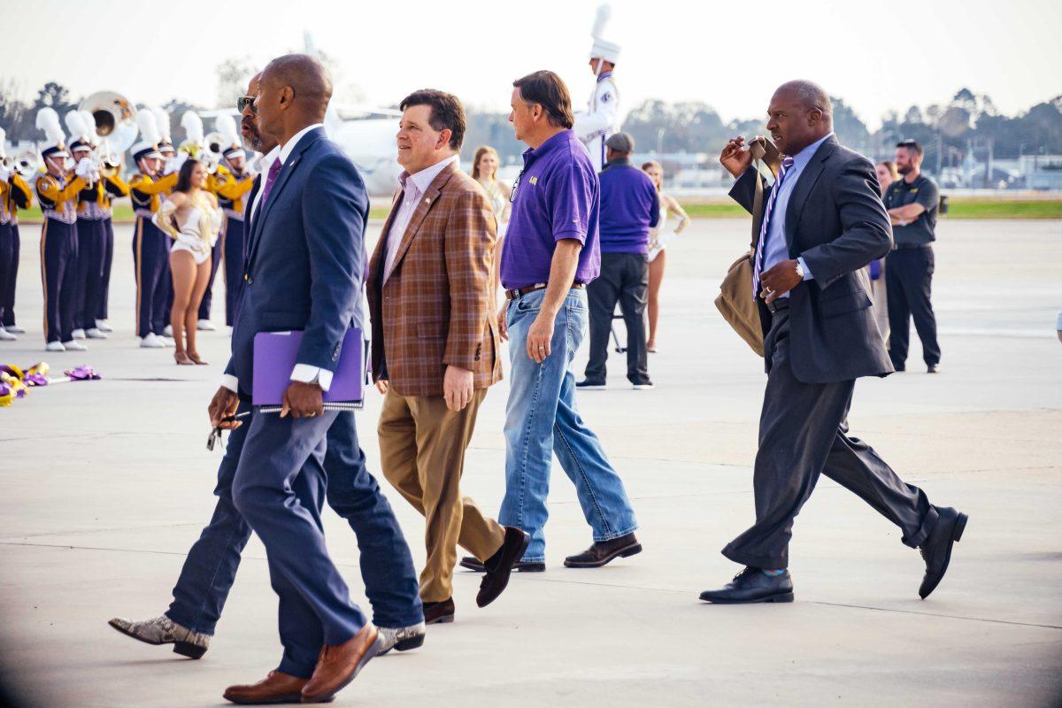 LSU athletics director Scott Woodward, President William F. Tate and Verge Ausberry walk away from the tarmac Tuesday, Nov. 30, 2021, after the arrival of newly hired football head coach Brian Kelly at the BTR Jet Center located in the Baton Rouge Metropolitan Airport on 4490 Blanche Noyes Avenue in Baton Rouge, La.