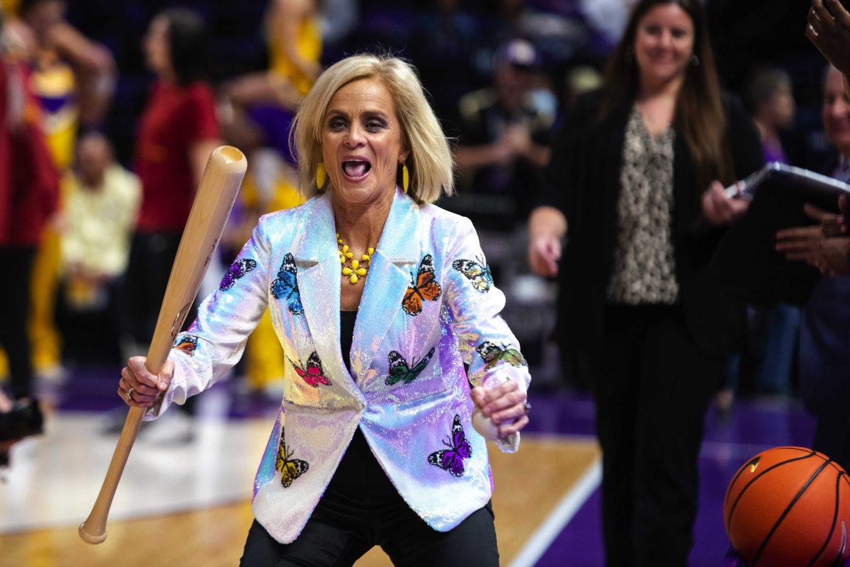 LSU women&#8217;s basketball head coach Kim Mulkey smiles as she holds a baseball bat before embracing Iowa State women&#8217;s basketball head coach Bill Fennelly Thursday, Dec. 02, 2021, before LSU&#8217;s 69-60 win against Iowa State in the Pete Maravich Assembly Center on North Stadium Drive in Baton Rouge, La.