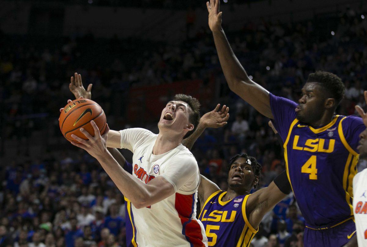 Florida forward Colin Castleton, left, drives through LSU forwards Mwani Wilkinson (5) and Darius Days (4) during the second half of an NCAA college basketball game Wednesday, Jan. 12, 2022, in Gainesville, Fla. (AP Photo/Alan Youngblood)