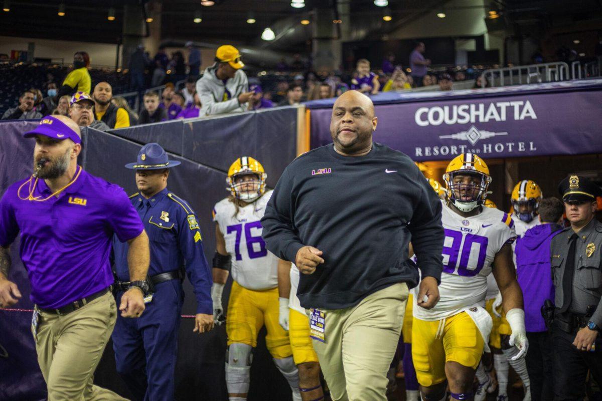 LSU football interim head coach Brad Davis enters the field with linemen Tuesday, Jan. 4, 2022, during LSU&#8217;s 42-20 loss against Kansas State at NRG Stadium in Houston, TX.