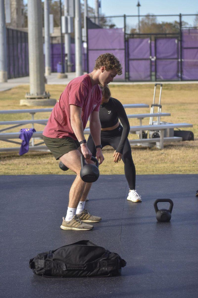 Two LSU students alternate kettlebells Wednesday, Jan. 26, 2022, at the UREC Outdoor Fitness Space.