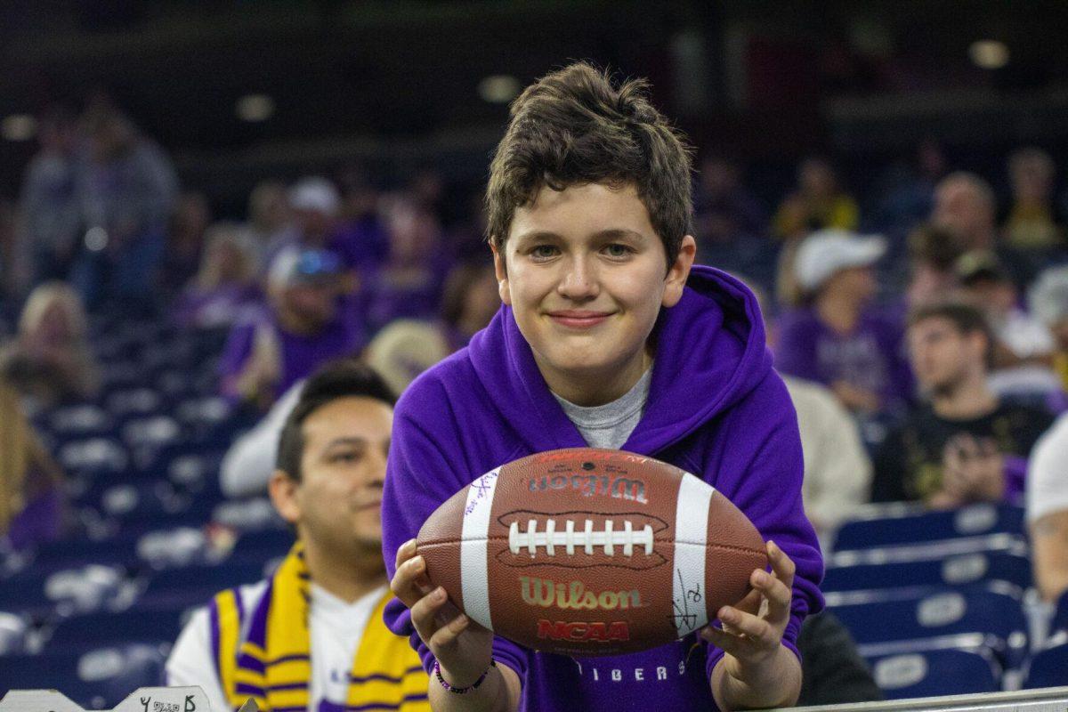 A fan holds a football signed by LSU football junior placekicker Cade York (36) Tuesday, Jan. 4, 2022, during LSU&#8217;s 42-20 loss against Kansas State at NRG Stadium in Houston, TX.