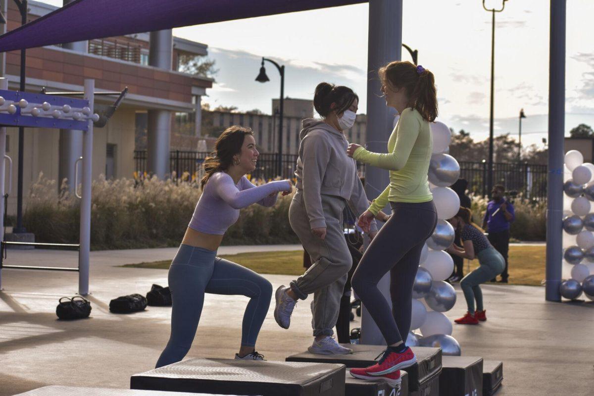 Three LSU students jump on and off of plyo boxes Wednesday, Jan. 26, 2022, at the UREC Outdoor Fitness Space.