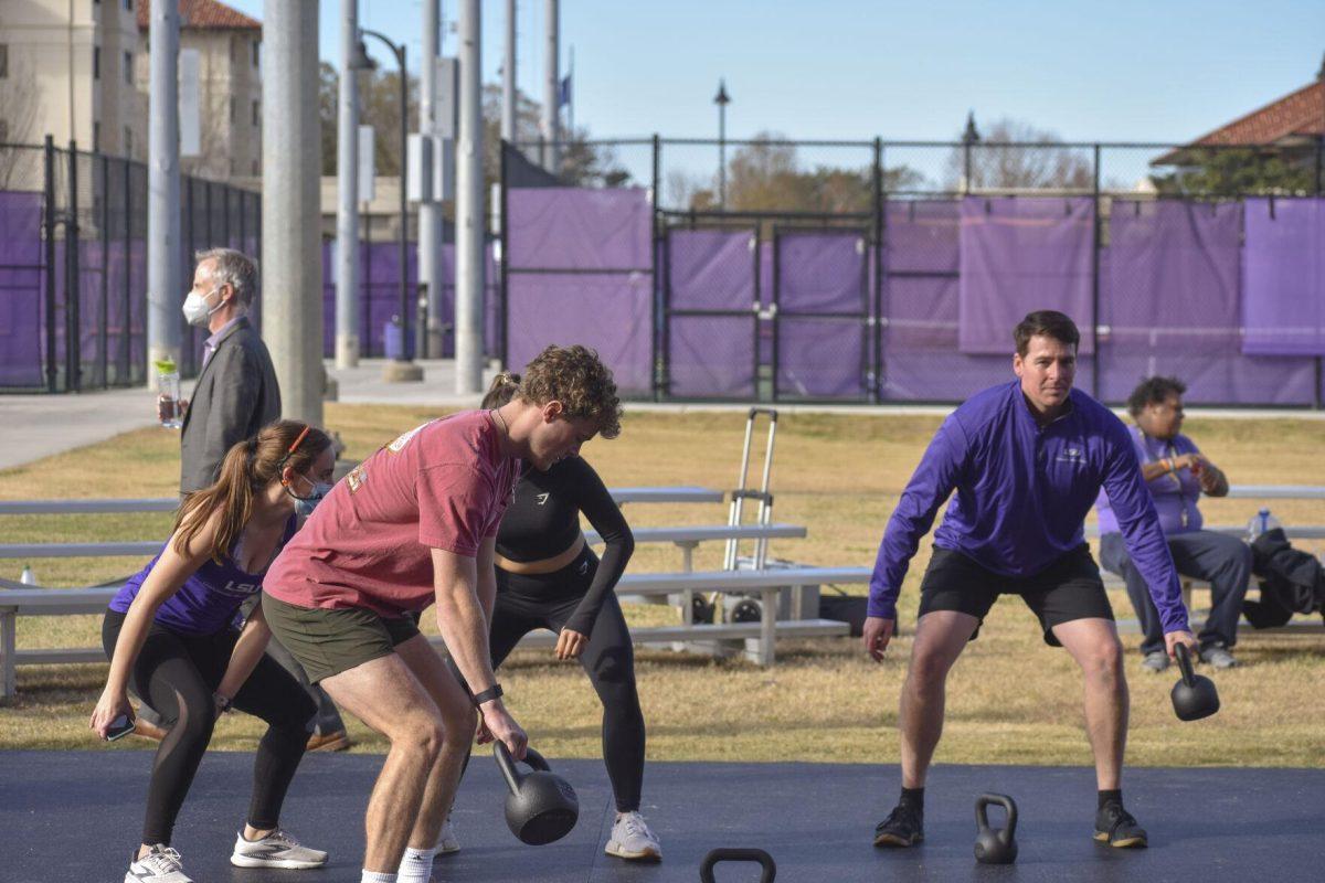 Three LSU students and a UREC instructor alternate kettlebells Wednesday, Jan. 26, 2022, at the UREC Outdoor Fitness Space.