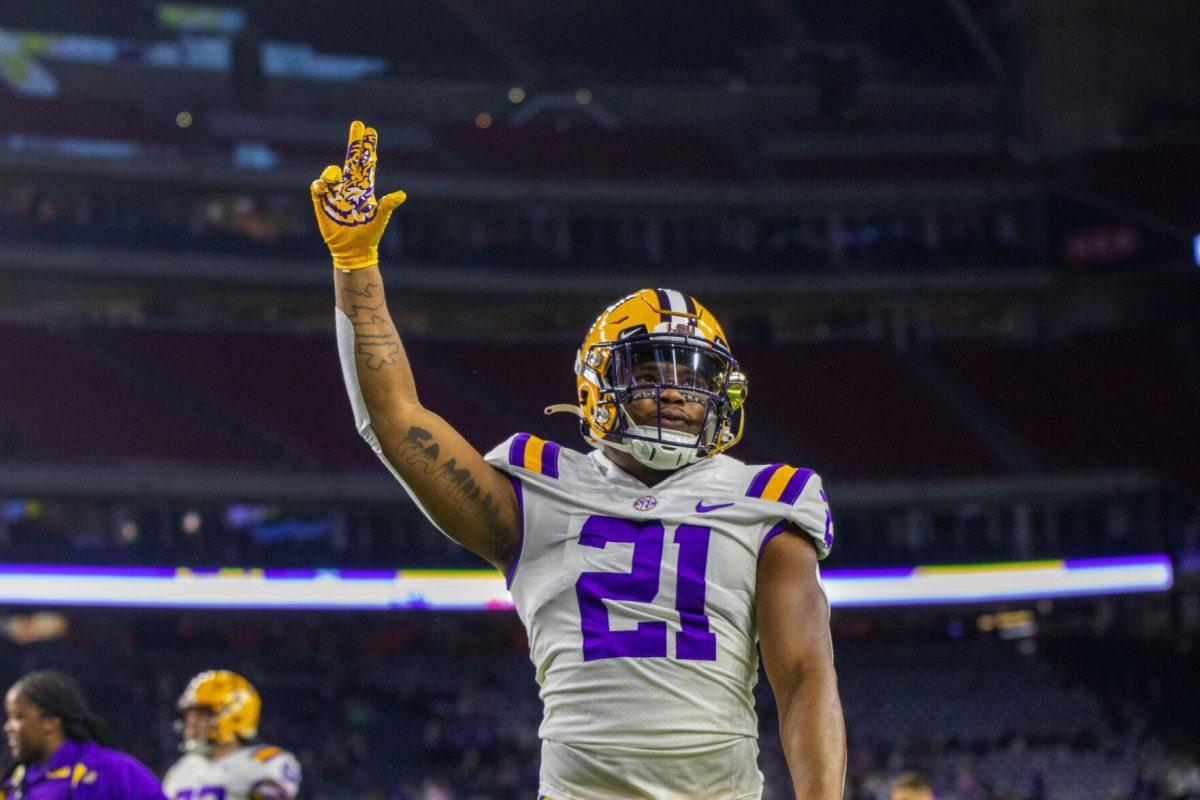 Rushing towards the fans, LSU football freshman running back Corey Kiner (21) shows school pride Tuesday, Jan. 4, 2022, during LSU&#8217;s 42-20 loss against Kansas State at NRG Stadium in Houston, TX.