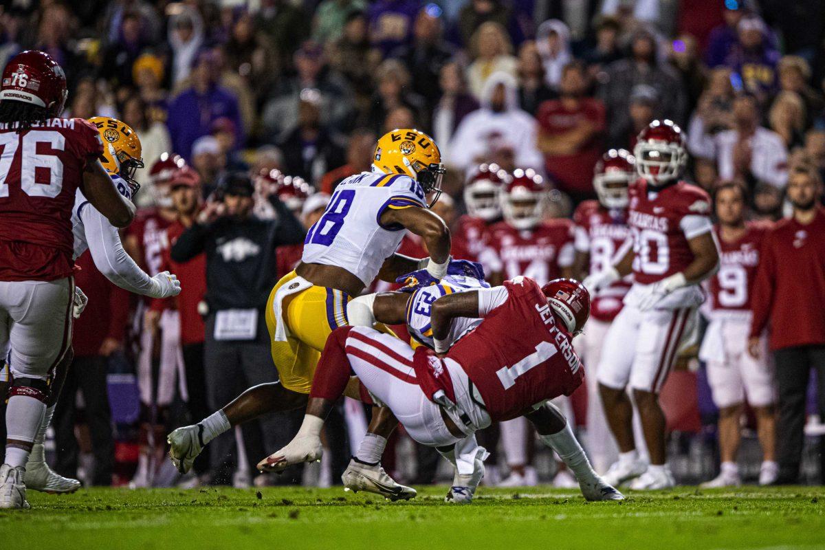 LSU football senior linebacker Damone Clark (18) lands a hard hit on an Arkansas quarterback Saturday, Nov. 13, 2021, during LSU's 16-13 loss against Arkansas at Tiger Stadium in Baton Rouge, La.