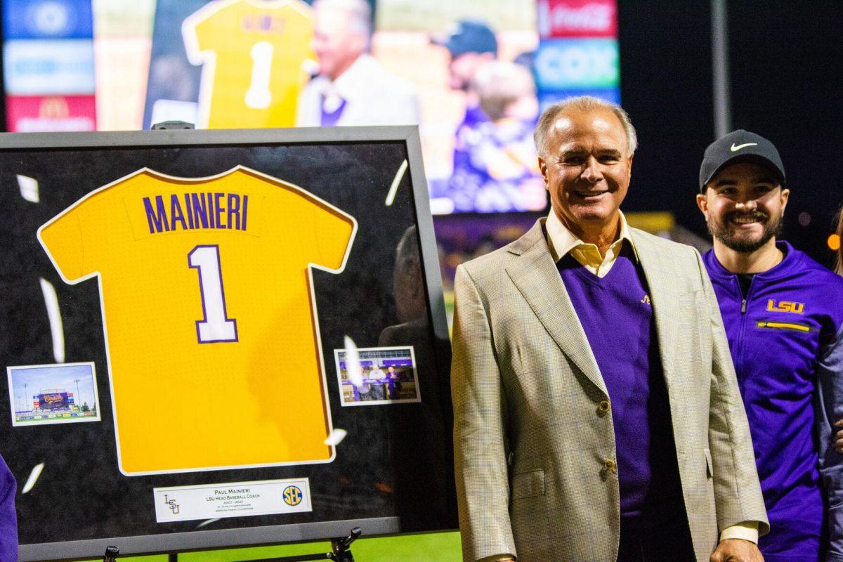 Former head coach Paul Mainieri poses with his framed jersey Friday, Feb. 18, 2022 before LSU's 13-1 win against Maine at Alex Box Stadium on Gourrier Avenue in Baton Rouge, La.