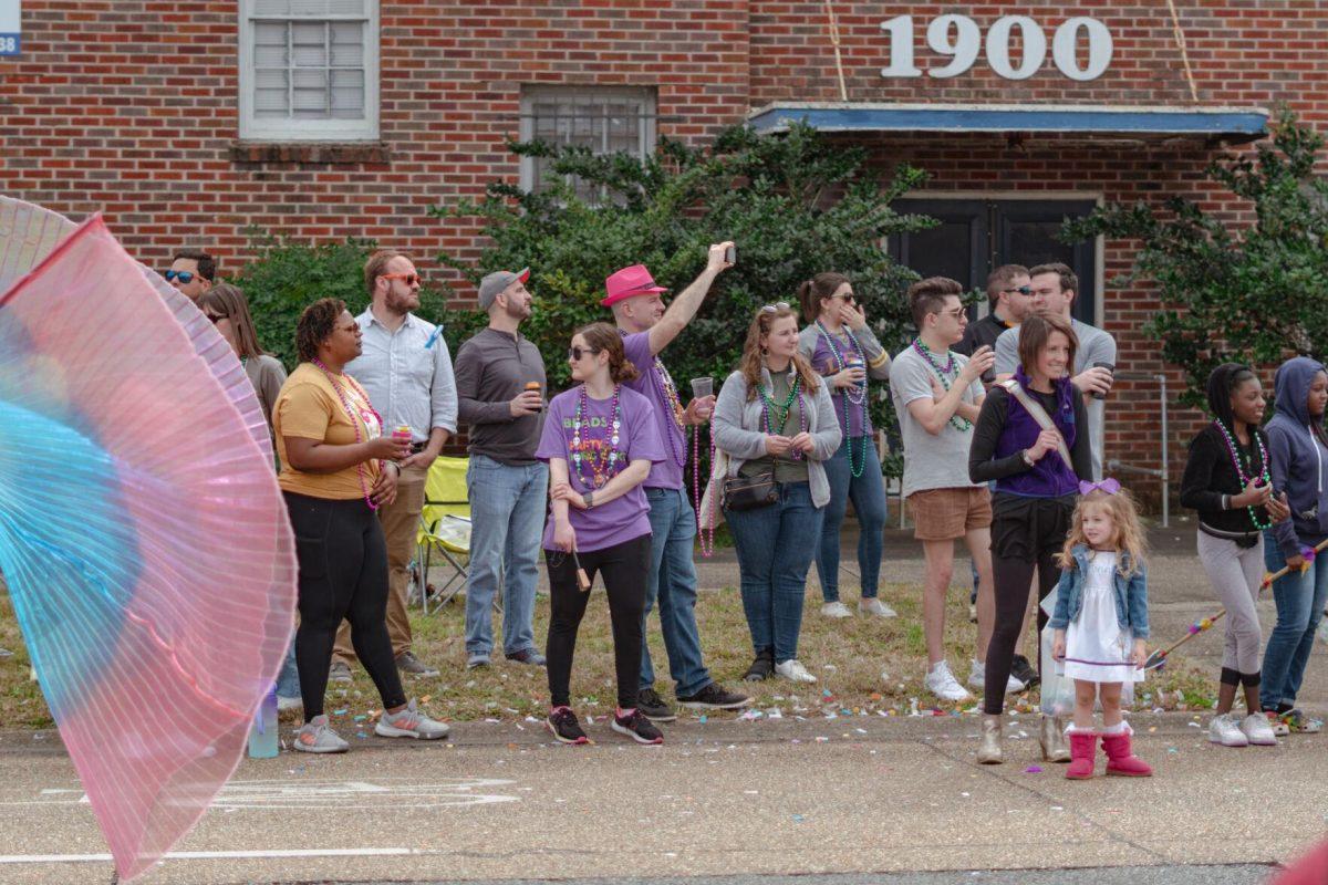 The crowd watches as performers pass on Sunday, Feb. 20, 2022, as part of the Mid City Gras parade on North Boulevard in Baton Rouge, La.