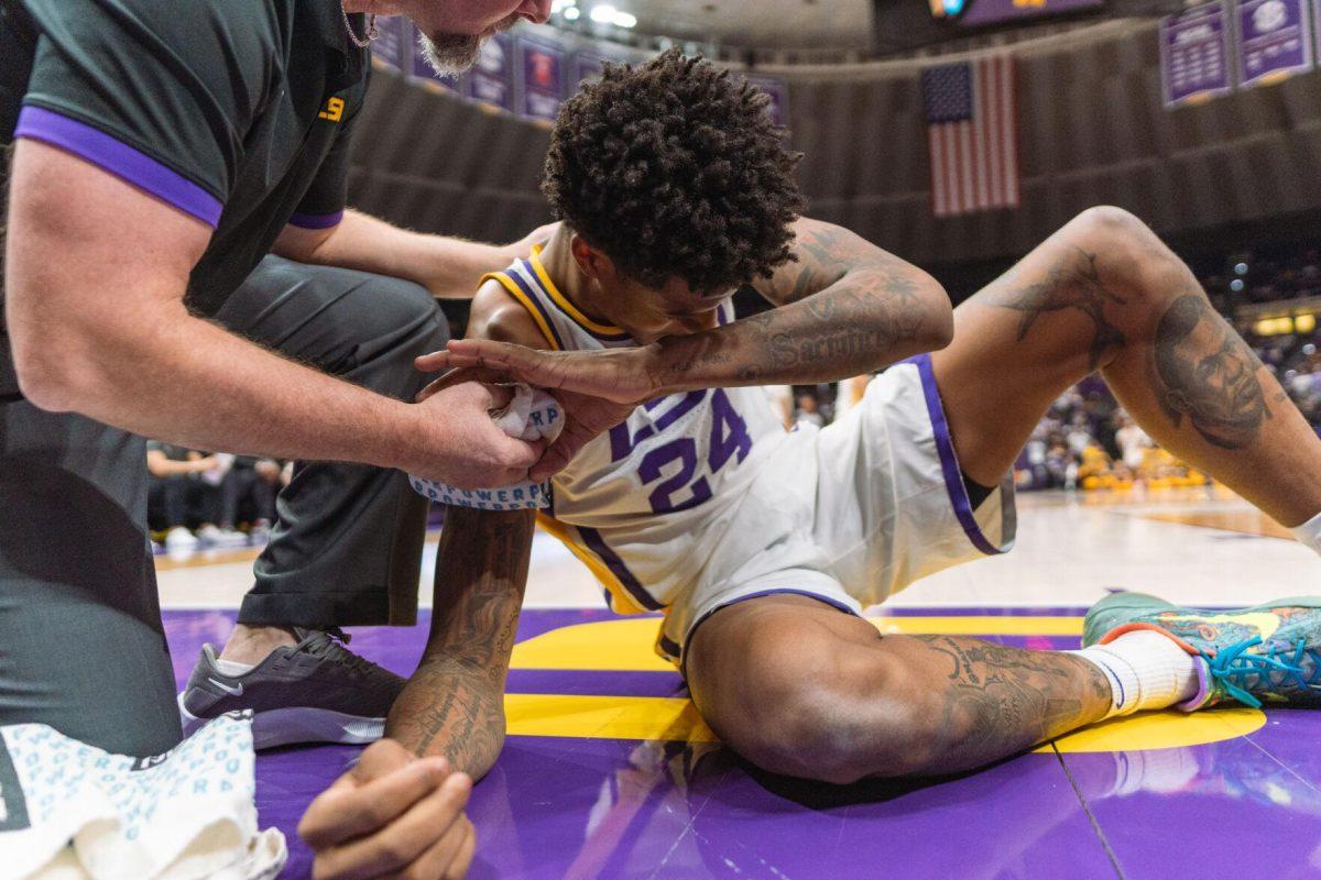 A trainer helps up LSU men&#8217;s basketball junior forward Shareef O&#8217;Neal (24) on Saturday, Feb. 12, 2022, during LSU&#8217;s 69-65 win over Mississippi State at the Pete Maravich Assembly Center on North Stadium Drive in Baton Rouge, La.