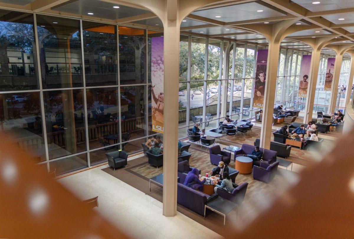 Reflections appear in the dark windows on Wednesday, Jan. 26, 2022, and students study during the day of Tuesday, Jan. 25, 2022, inside the LSU Student Union on Highland Road in Baton Rouge, La.