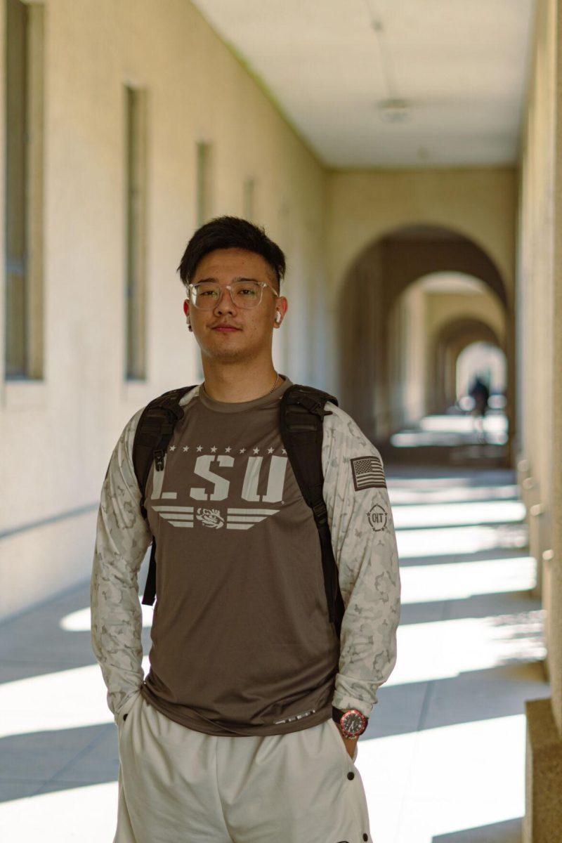 LSU sophomore criminology major Ruizhou Zhang wears an LSU shirt on Thursday, Feb. 10, 2022, as he walks between classes in the LSU Quad in Baton Rouge, La.