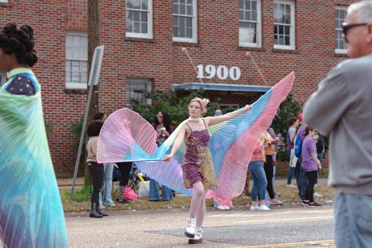 A woman waves her cape on Sunday, Feb. 20, 2022, as part of the Mid City Gras parade on North Boulevard in Baton Rouge, La.