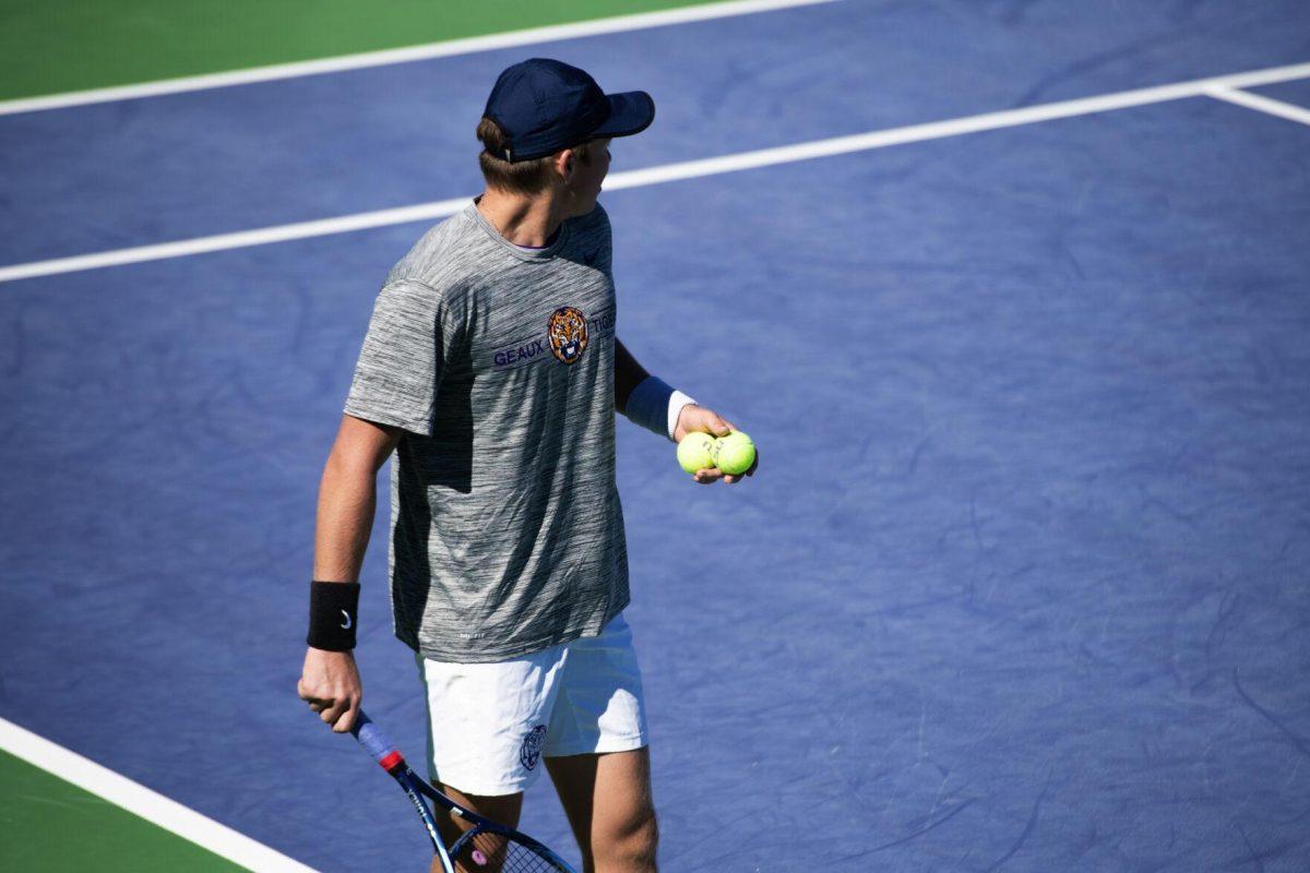 LSU men's tennis junior Boris Kozlov holds two tennis balls before his serve Sunday, Feb. 13, 2021 during LSU's 6-1 win over Purdue at the LSU Tennis Complex on Gourrier Avenue in Baton Rouge, La.