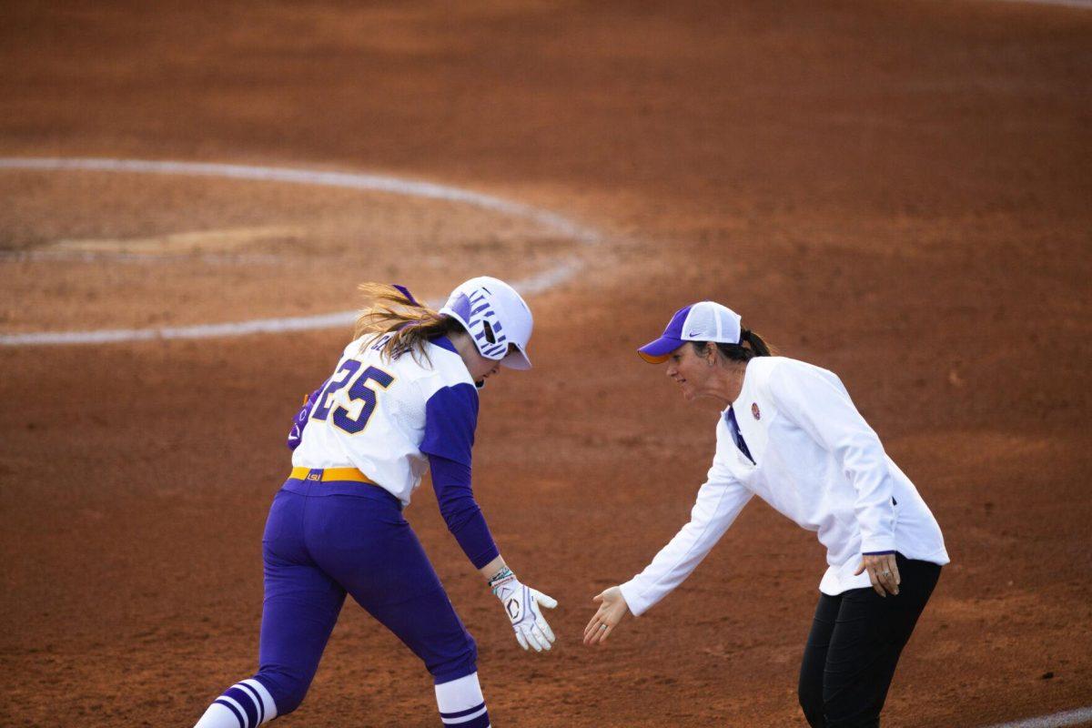 LSU softball junior infielder Georgia Clark (25) claps hands with head coach Beth Torina after she hits a homerun Saturday, Feb. 12, 2022, during LSU’s 8-1 win against South Alabama at Tiger Park on Skip Bertman Drive in Baton Rouge, La.